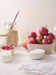 Ingredients for making overnight oats or a porridge bowl. Grains, fruits, berries and dairy products. White background