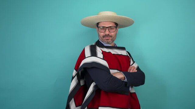 retrato hombre maduro vestido con ropa tradicional huaso chileno con los brazos cruzados, estudio fondo azul