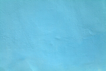 Sky blue or sapphirine wall, texture, background. The building wall, painted with water-based paint. Smooth (flat) surface in light-blue color with small dents and unevenness. Bluish backdrop