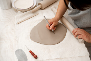 Preparing clay for cutting and assembling it. Slab building method in ceramics crafting. Using a...