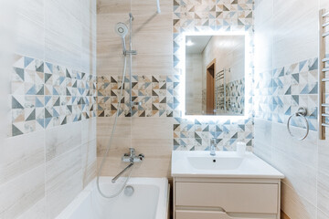 The stylish bathroom includes a cozy bathtub, a modern sink, an elegant mirror, and a spacious...