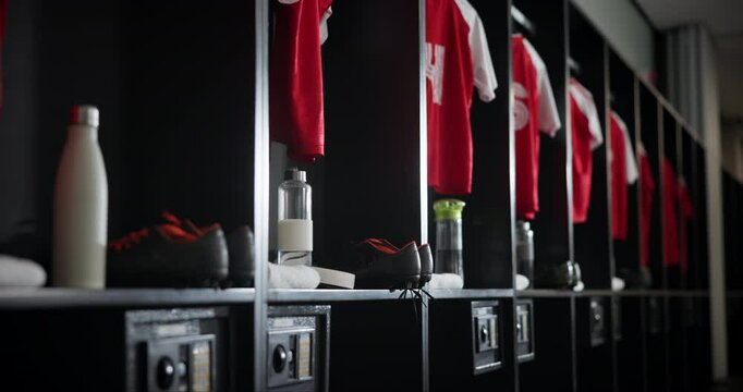 Gym, interior and empty locker room with sport jersey, water bottle and fitness equipment. Soccer, change and uniform at club with clothes, shoes and football cleats in dressing closet for storage