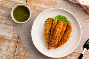 Deep fried Capelin Fish (Shishamo),Thai fried battered egg fish in white plate.snack food served with seafood sauce.Top view.