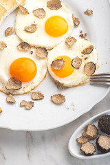 Black truffles gourmet  breakfast, brunch. Fried eggs recipe with black truffles and toast bread , white background. Internet banner, top view. Healthy recipe of Piedmont, Italy, Spain and France