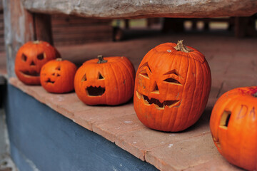 Obraz premium Group of Halloween pumpkins on a brick floor. Halloween orange pumpkins. Jack o lantern