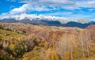 Fototapeta premium Amazing autumn landscape with snowy mountains and autumn colors. Mountain landscape of Romania. Piatra Craiului National Park from Romania.