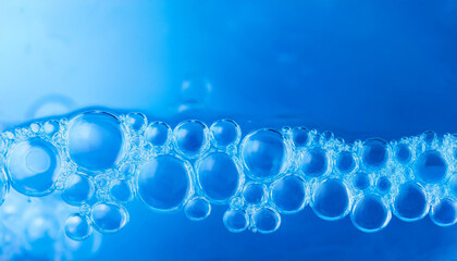 Shimmering soap bubbles on vibrant blue background. Glowing shades and fluid patterns. Close-up.