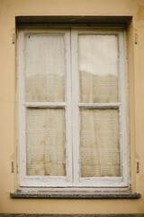 The texture of an old wooden window with curtains. White painted window frame
