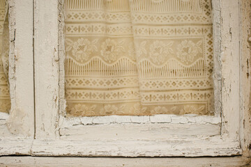 The texture of an old wooden window with curtains. White painted window frame