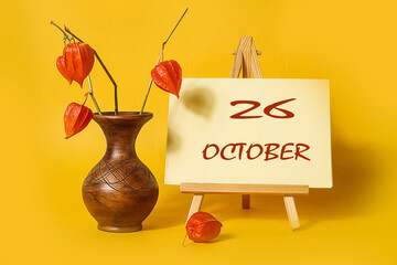 Calendar for October 26: numbers 26, name of the month October in English, bouquet of physalis,...