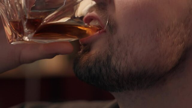Close up happy laughing Caucasian drunk addict man male bearded businessman guy client customer drinking glass expensive alcohol liquor whiskey at home room. Alcoholism addiction unhealthy lifestyle