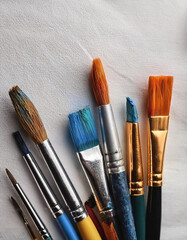 Fototapeta premium Paint and brushes lie on a white canvas. Creative Activities