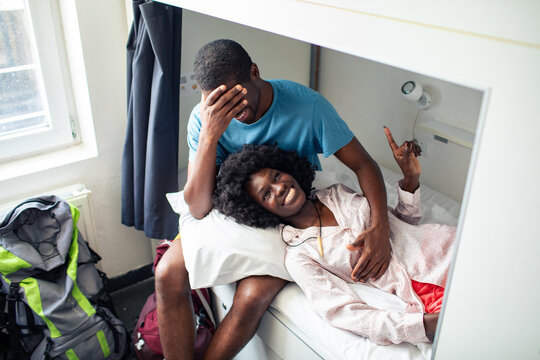 Smiling young black couple relaxing together in a shared bunk bed room