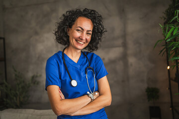 Portrait of smile female doctor in blue scrubs pose with stethoscope