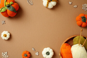 Handcrafted Crochet Pumpkins and Wooden Leaves on Brown Background. Autumn, Fall Concept.