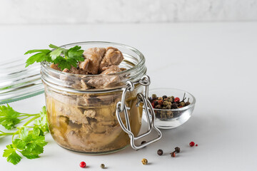 Cod liver in a jar with parsley and pepper on white background. Natural source of omega 3 and...