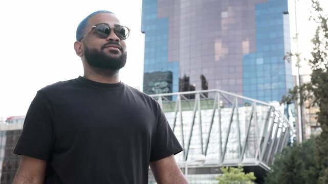 Confident african american man with sunglasses walking in a modern building environment. Lifestyle and successful success life. Financial freelancer. Urban street style concept.MOV