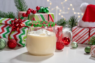 A glass of milk with a green and red ribbon on top