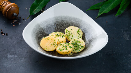 Russian food garnish baked potato wedges with herbs in plate.