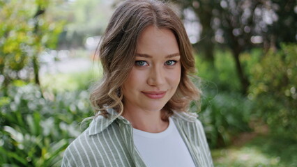 Portrait smiling woman park looking camera confidently. Beautiful lady standing