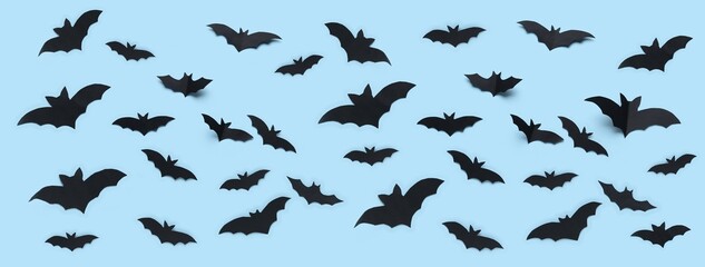 Many black paper bats for Halloween party on blue background