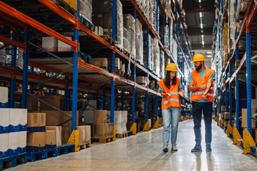 Warehouse team analyzing inventory tasks while walking along