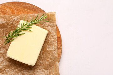 Wooden board with fresh butter and rosemary on white background