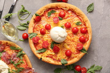 Tasty pizzas with Burrata cheese on grey background