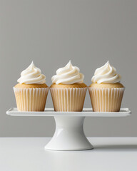 White icing three cupcake mockup with minimal decor, smooth icing, natural lighting, single white ceramic pedestal