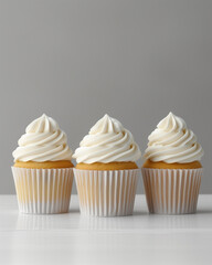 White icing three cupcake mockup with minimal decor, smooth icing, natural lighting, grey background