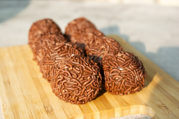 Close-up of chocolate brigadeiros, a popular Brazilian dessert, on a wooden board.