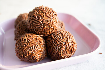 Close-up of a plate of chocolate brigadeiros, a popular Brazilian dessert.