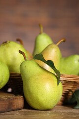 Fresh green pears and leaf on wooden table, closeup