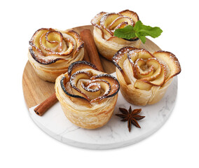 Freshly baked apple roses, cinnamon sticks, anise star and mint isolated on white. Puff pastry