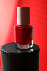 Obraz premium Nail polish in bottle on red background