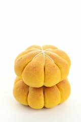 Stack of tasty pumpkin shaped buns on white background