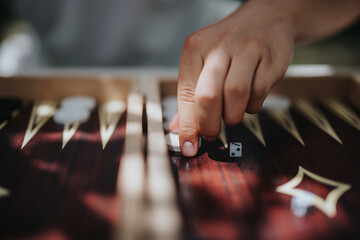 A hand rolling dice on a backgammon board, capturing the essence of strategic game play and leisure...