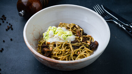 Lunch pasta with with mushrooms, egg and pine nuts.