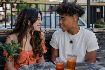 A couple sitting together at a table, possibly sharing a meal or having a conversation