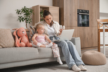 Little girl ill with chickenpox and her mother video chatting on sofa at home