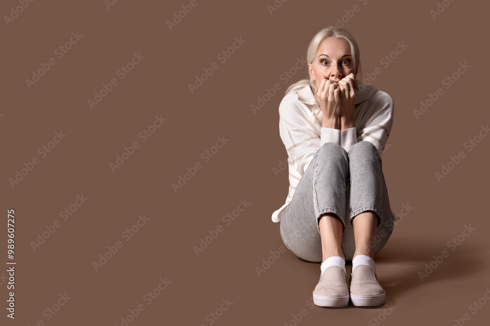 Sticker Mature woman having panic attack on brown background