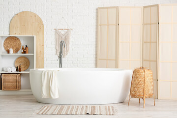 Interior of bathroom with wooden folding screen, bathtub and shelf unit
