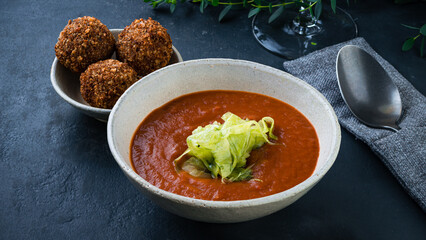 Fresh tomato soup with fried cheese balls and herbs.
