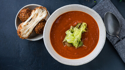 Tomato cream soup with fried cheese balls and herbs.