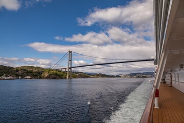 Obraz premium Passing Under the Askøy Suspension Bridge Across the Byfjorden, From the deck of a cruise ship leaving Bergen, Norway in Summer