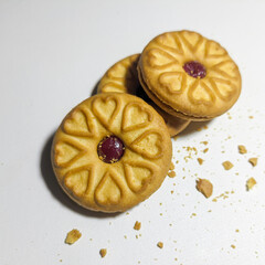 Milk biscuits filled with berry jam are isolated on a white background. Biscuits with heart shapes. Valentine's day heart. Top view. 