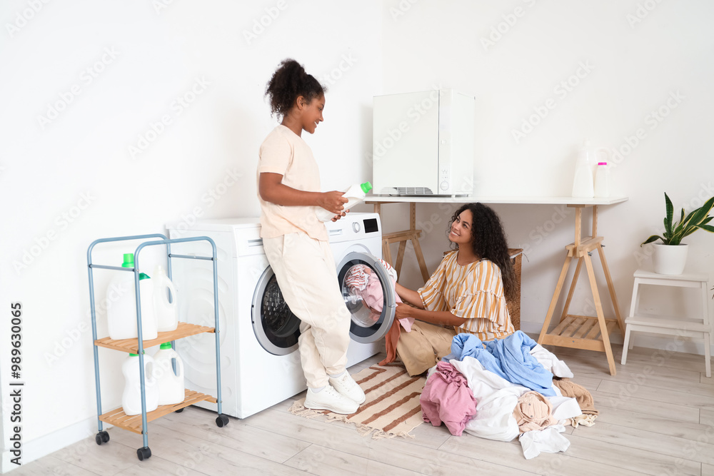 Canvas Prints African-American woman and her daughter doing laundry at home