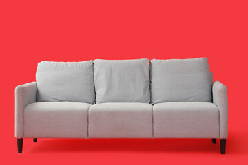 Grey sofa on red background