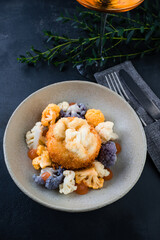 Snack breaded mozzarella cheese ball with cauliflower and sauce.