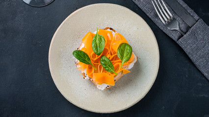 Bruschetta with slices of pumpkin, cream cheese and spinach.
